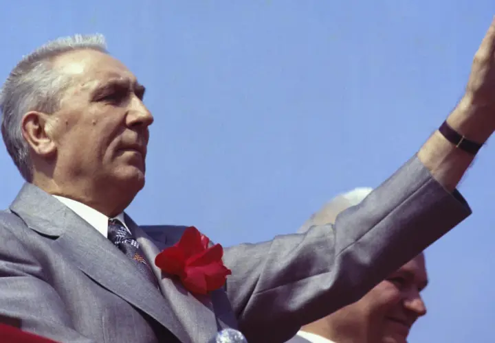 Edward Gierek, wznosząc rękę, symbolizuje czasy, gdy starał się budować Polskę, inwestując w rozwój przemysłu i poprawę bytu obywateli.