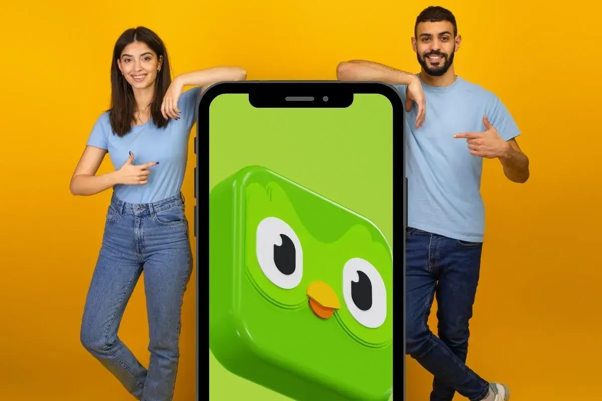 Para, co po 5 poziomie Duolingo? Młodzi ludzie wskazują na ekran telefonu z sową Duo.