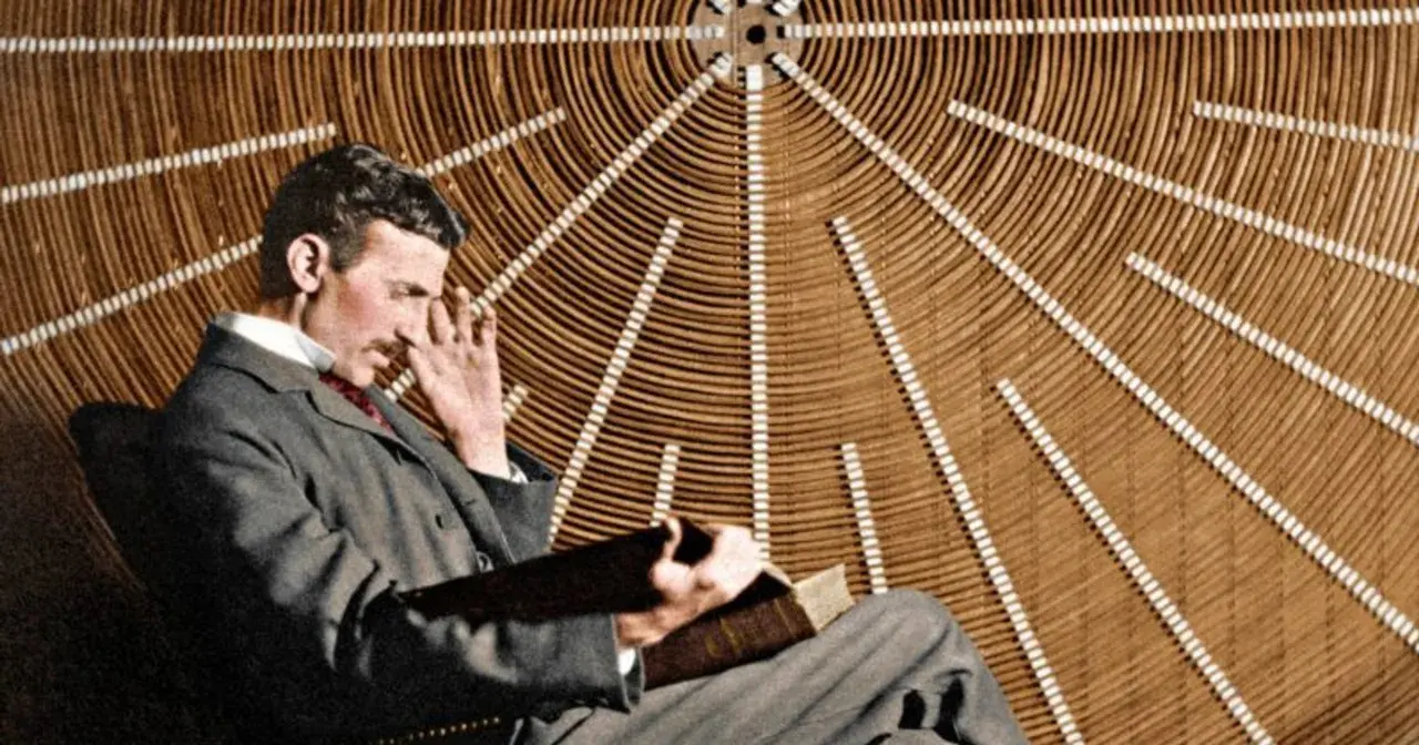 Nikola Tesla w okularach, zamyślony, siedzi przed aparaturą, która mogłaby być prototypem jego "promienia śmierci".